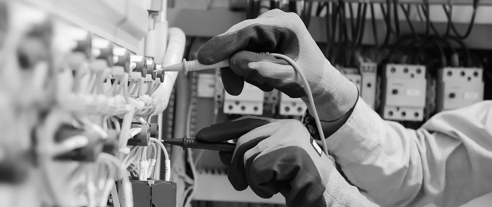 An electrician testing wiring inside an electrical panel