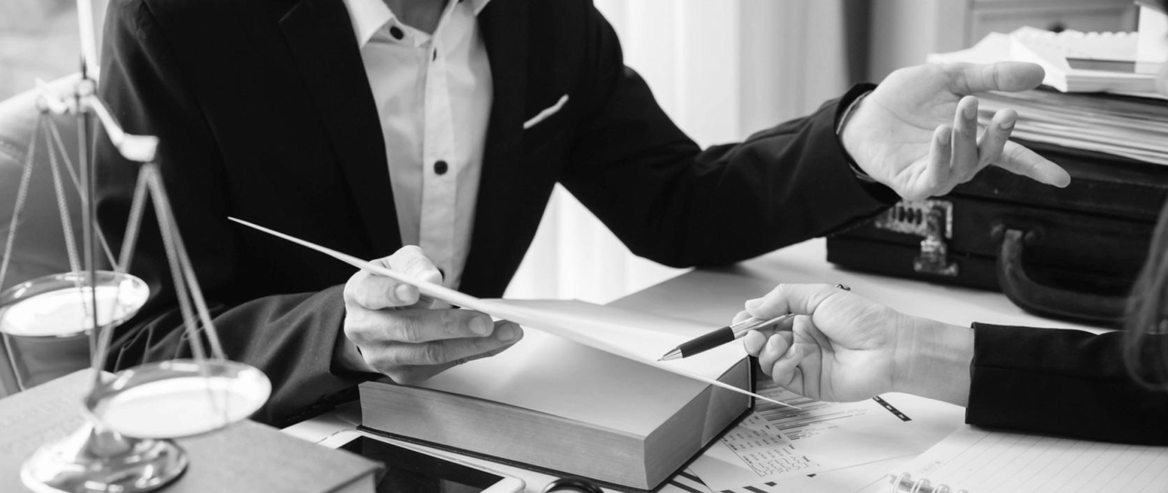 An attorney reviews a document with a client in a modern office setting
