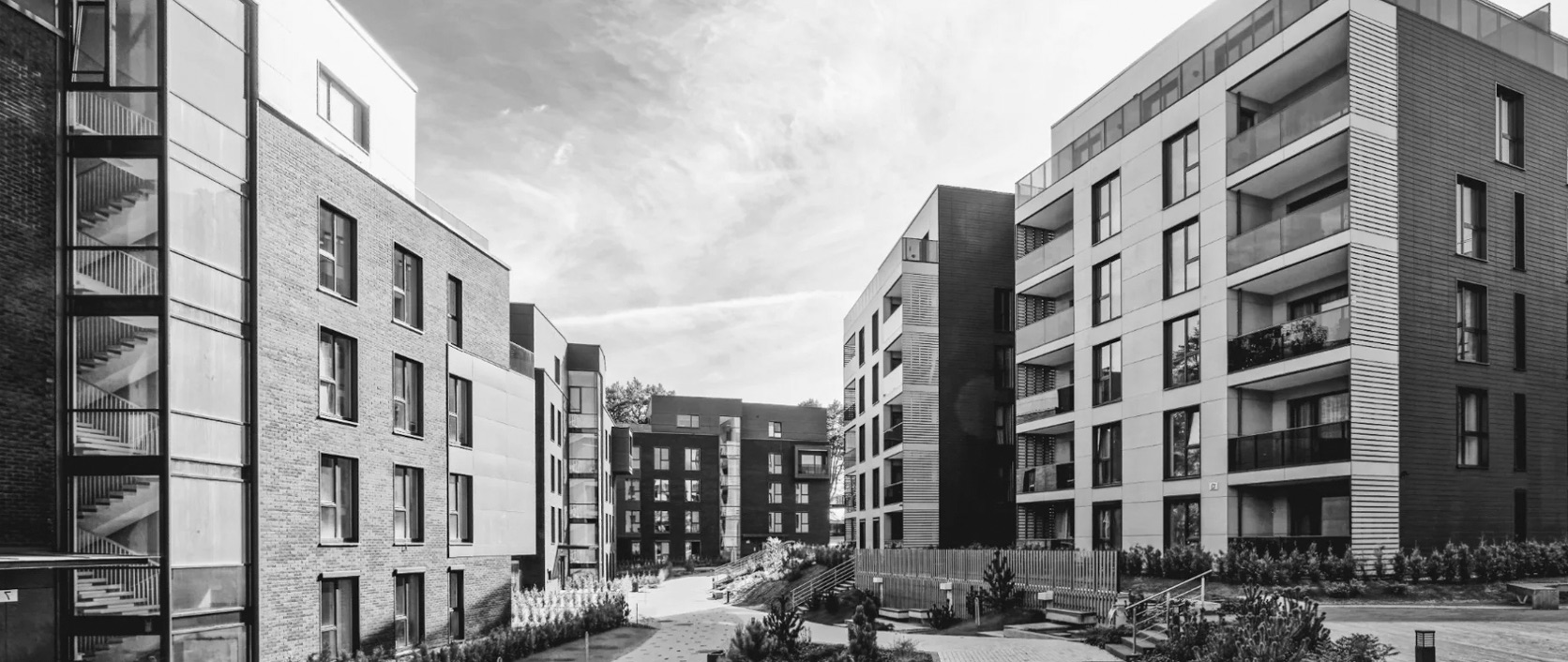 A multifamily residential property exterior with landscaped courtyard walkways